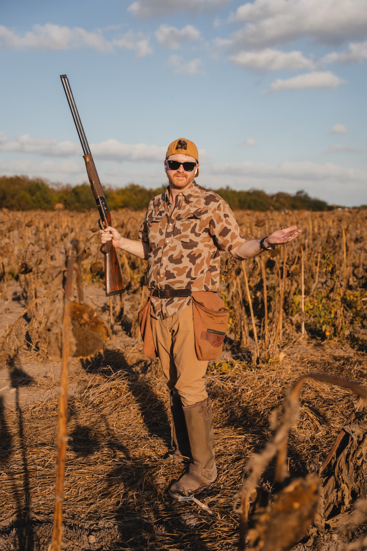 Hunter in retro camo standing in the sunflower field