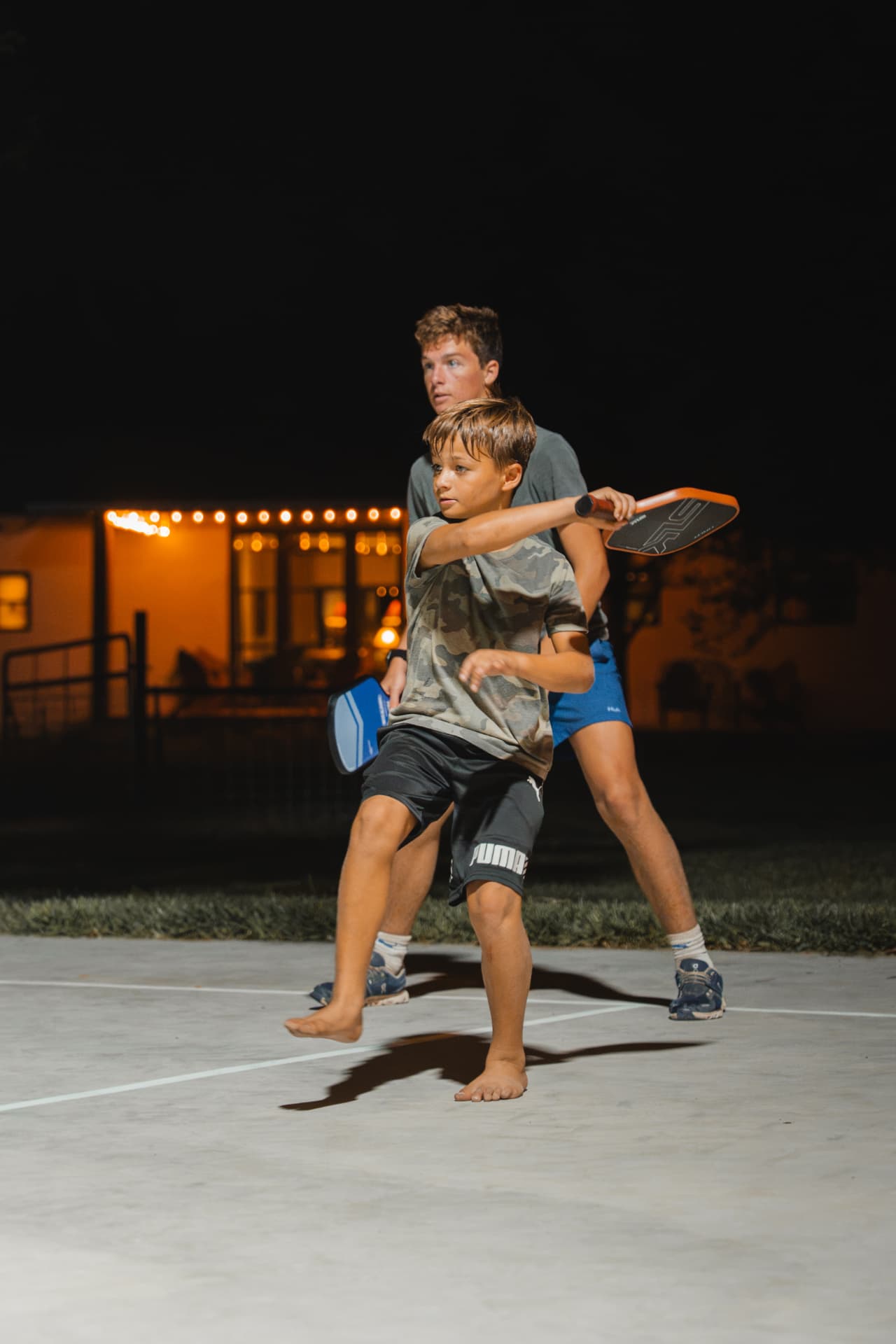 Barefoot swings on the pickleball court after dark