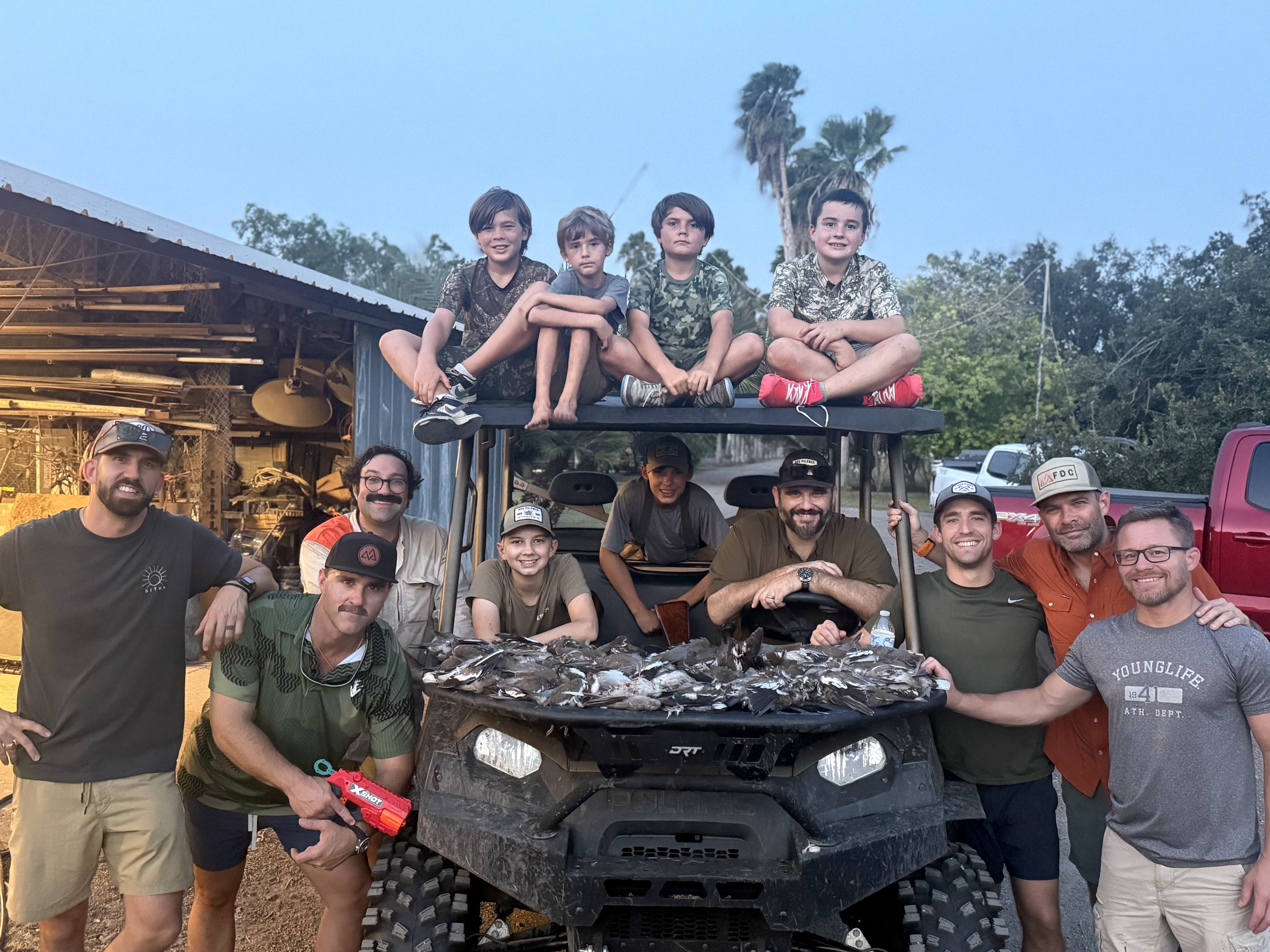 Crew and kids posing with the day's dove harvest on the Polaris