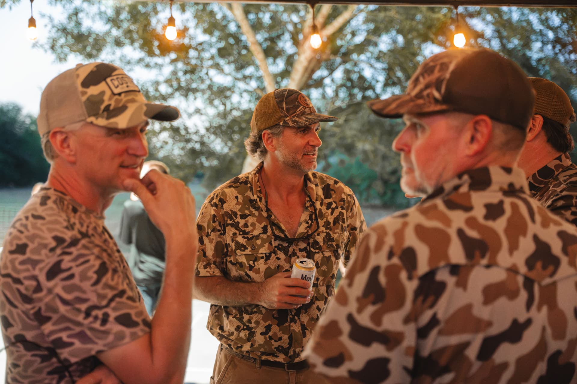 Camo shirts and canned drinks under the patio string lights