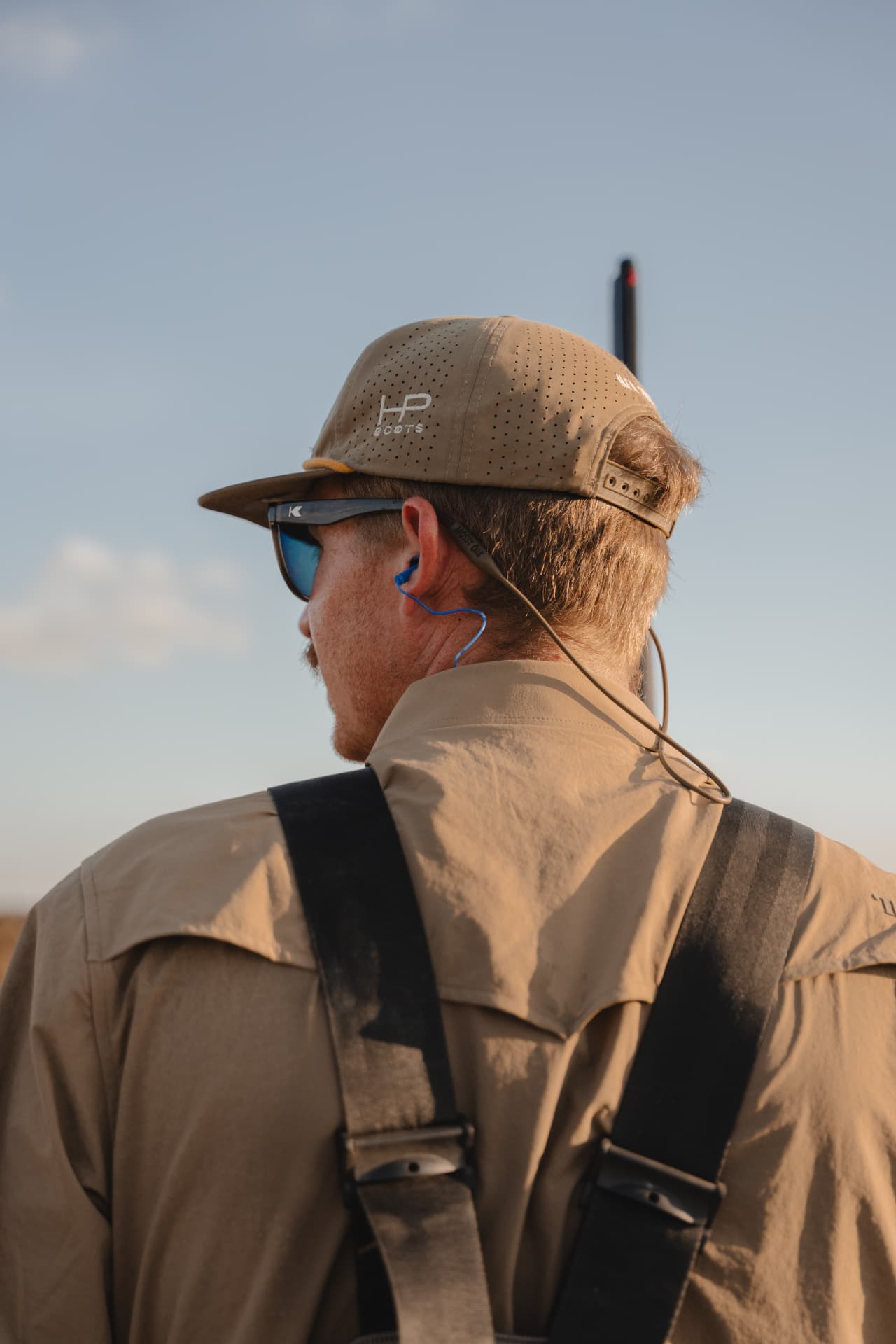 Hunter keeping watch on the horizon, shotgun in hand