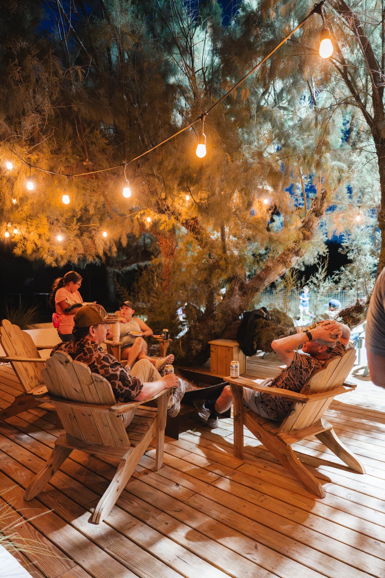 Relaxing in wooden lawn chairs under the string lights