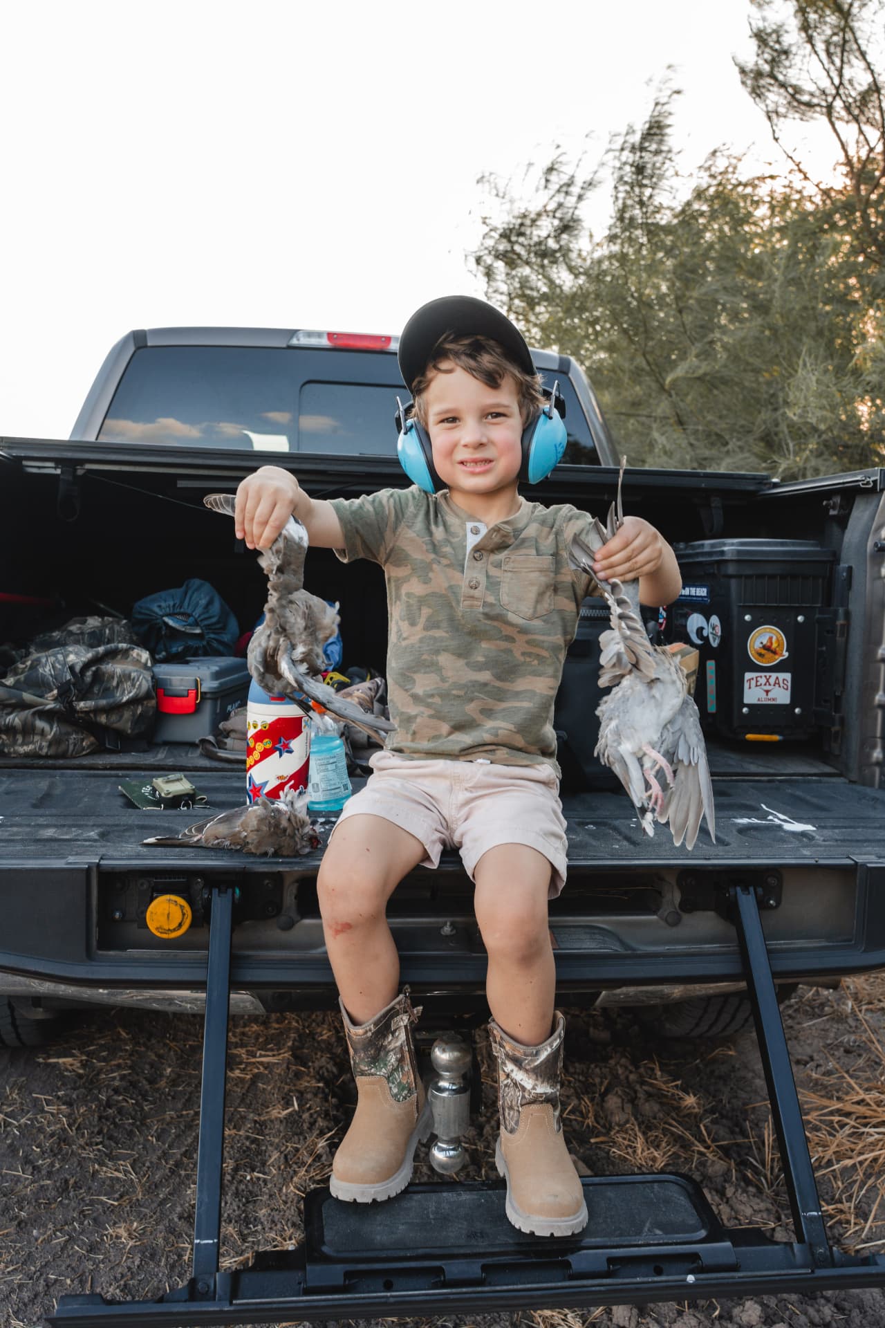Young hunter showing off the doves from the tailgate