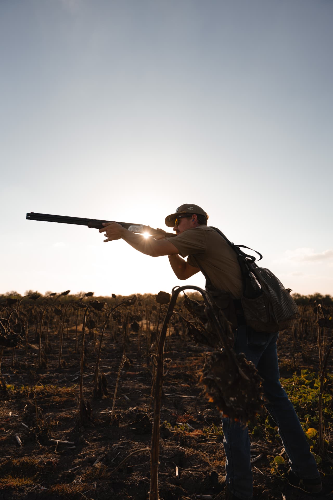 Hunter drawing a bead against the setting sun