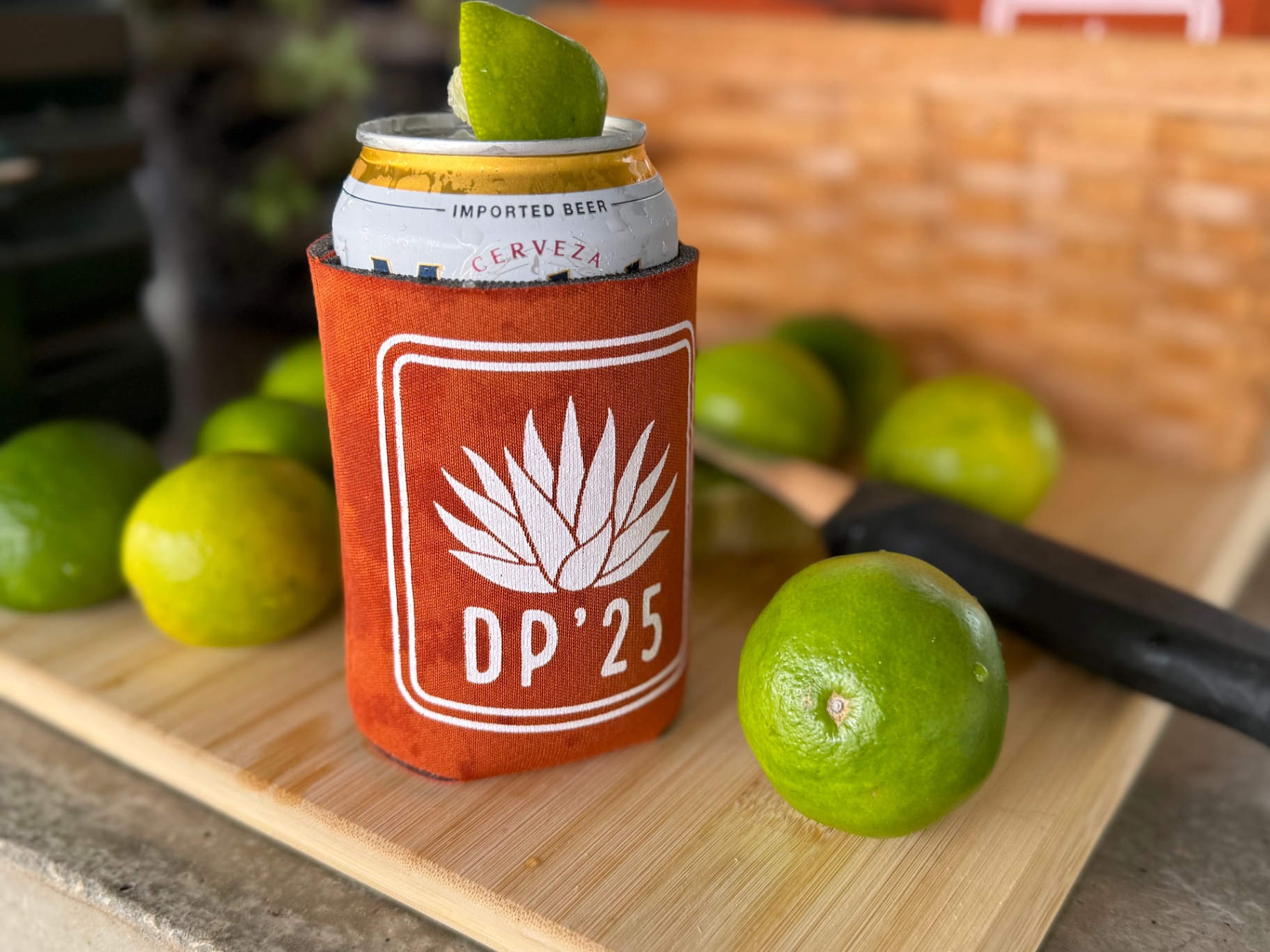 DP'25 koozie with cerveza and limes