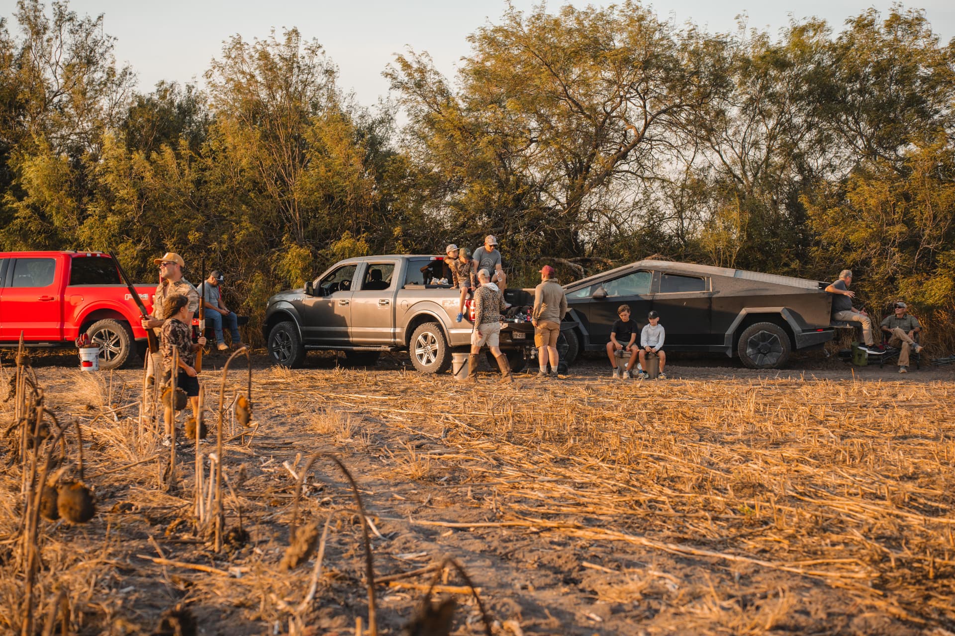 The crew gathered by the trucks along the tree line