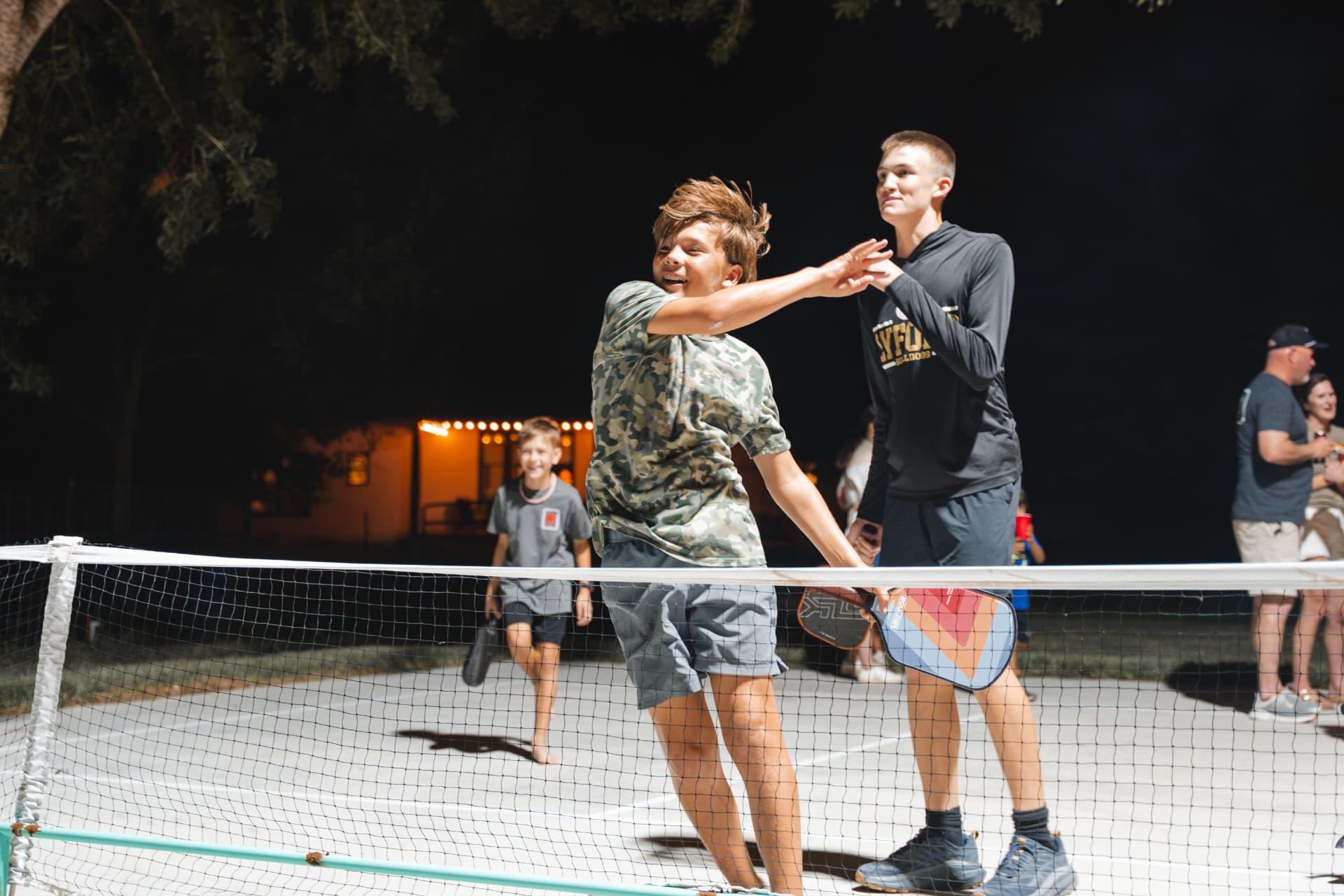 Nighttime pickleball match under the court lights