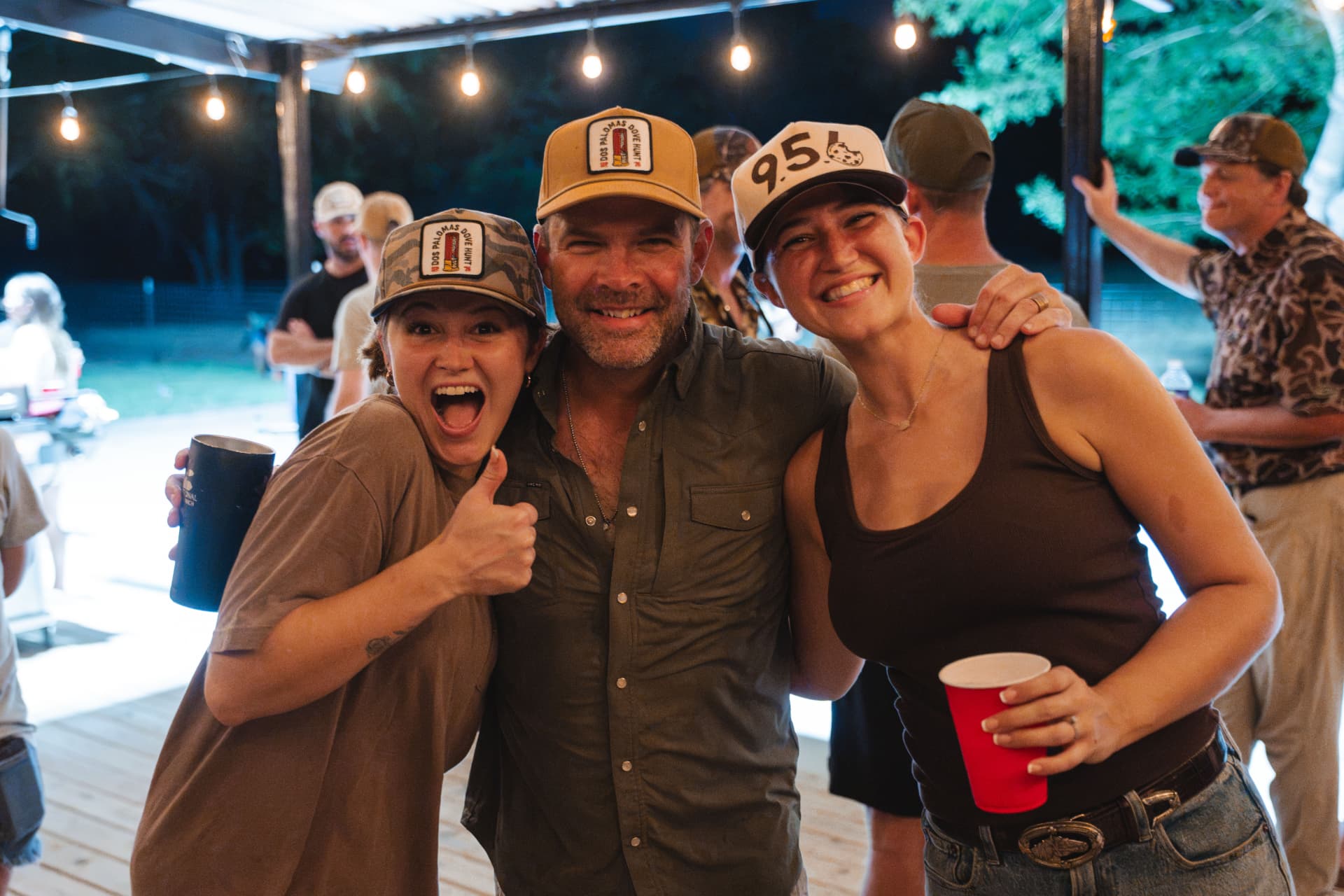 Caps on, raising a toast at the patio party